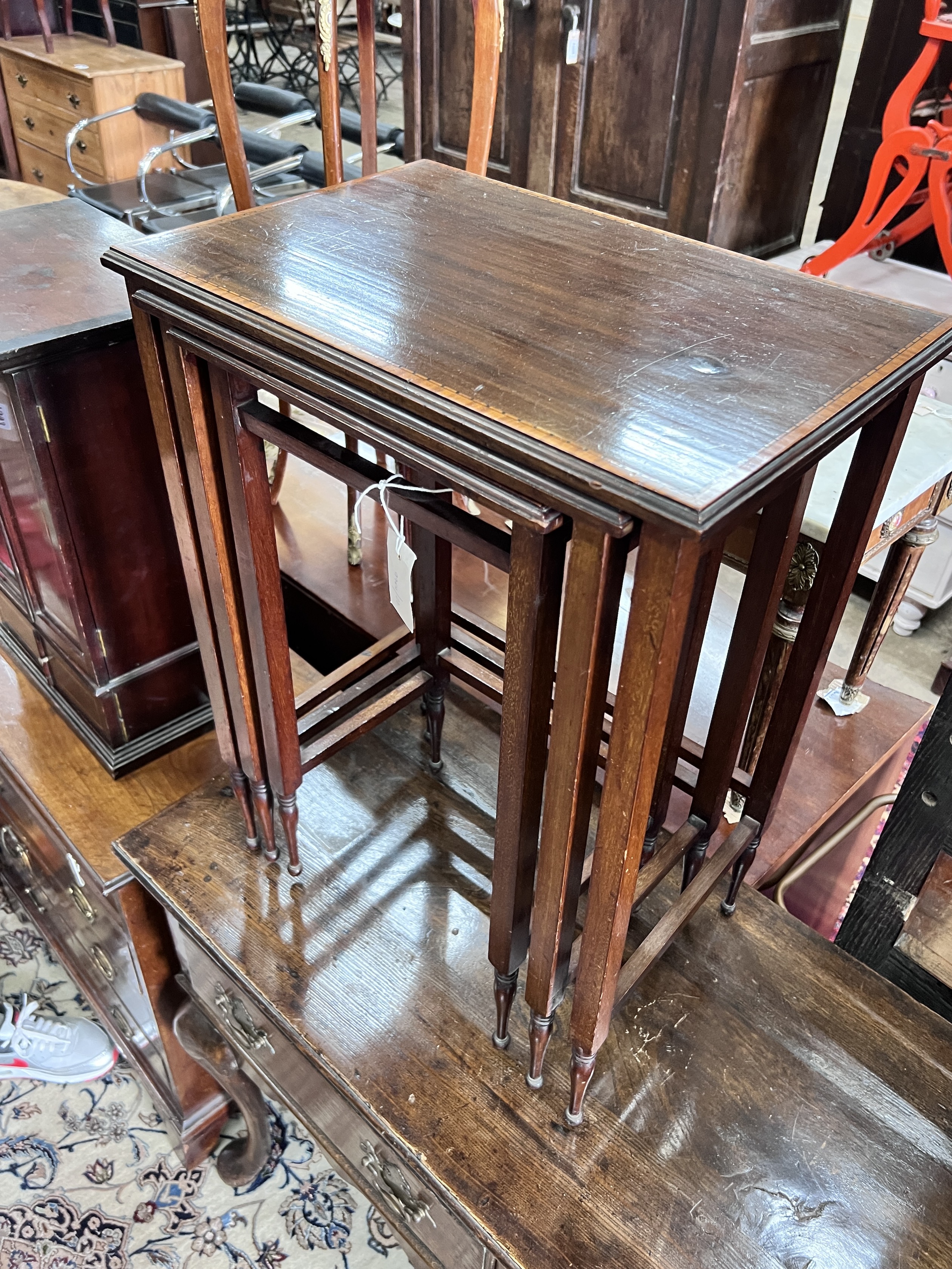 A nest of three Edwardian satinwood banded rectangular mahogany tea tables, width 48cm, depth 32cm, height 64cm